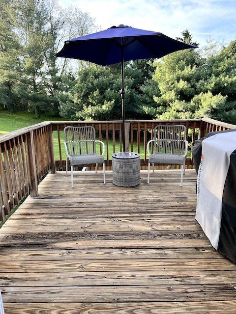 a wooden deck with chairs and an umbrella on it .