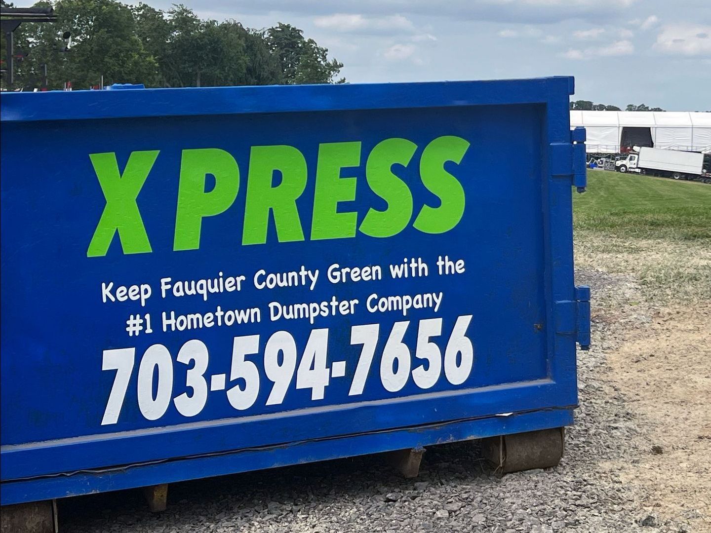 a blue dumpster that says xpress keep fauquier county green with the # 1 hometown dumpster company