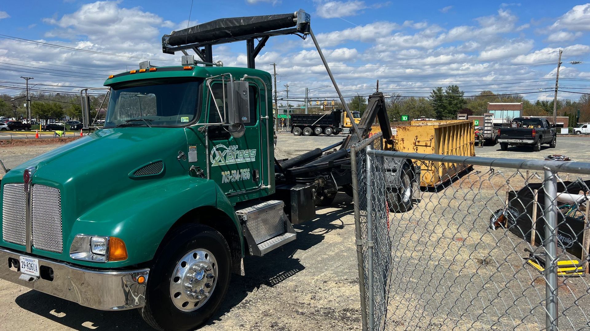 Xpress Dumpster Rentals truck delivering a dumpster on time to a construction site in Manassas, VA.