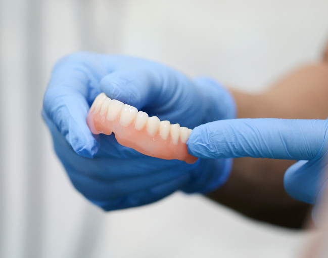 Dentures, upper and lower set, light pink base, white teeth.