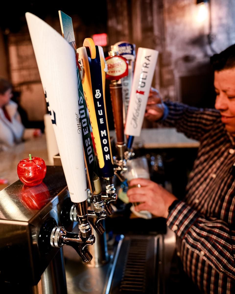 A man is pouring beer from a tap that says ultra