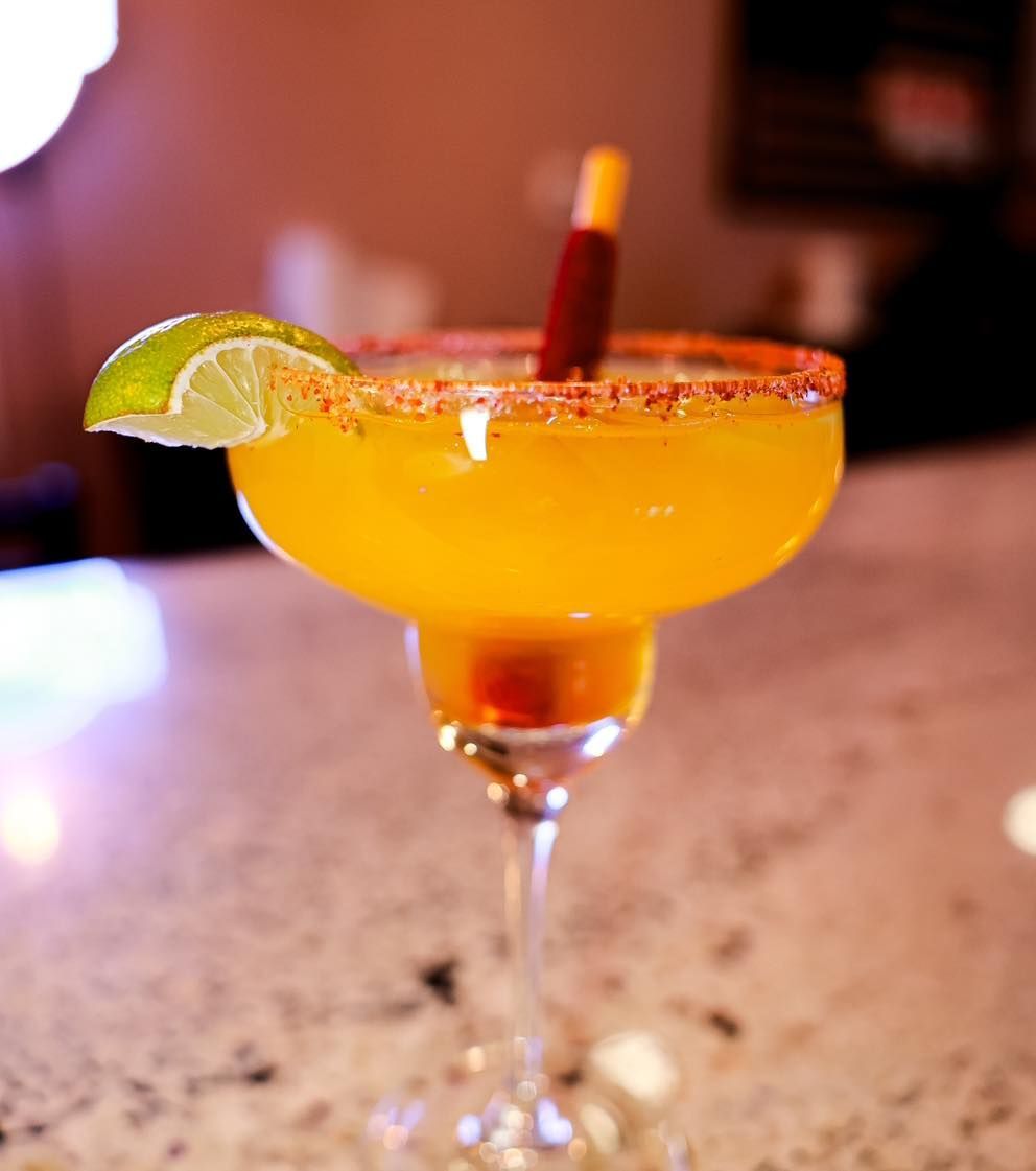 A margarita with a straw and a lime wedge