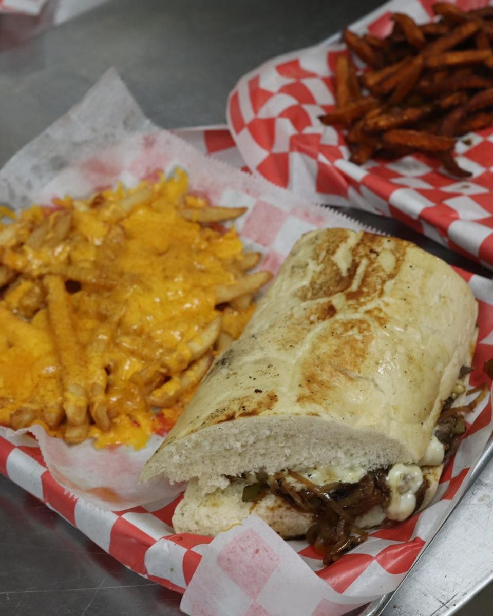 A sandwich and french fries on a checkered paper