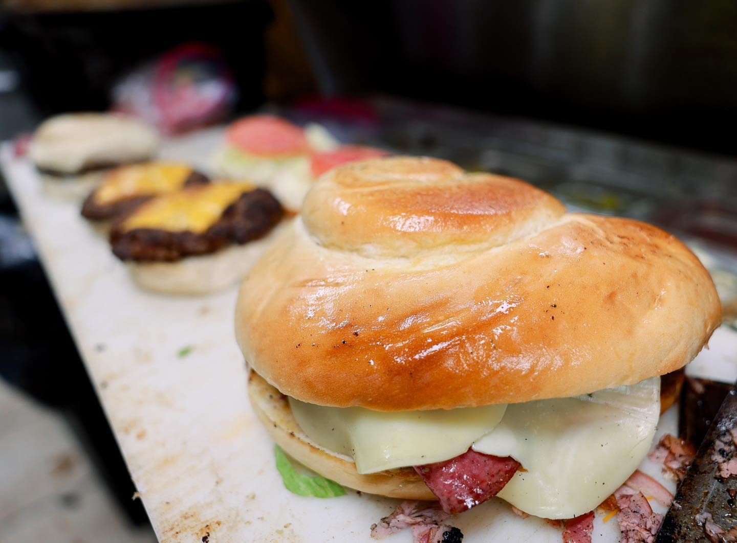 A close up of a sandwich on a bun on a table.