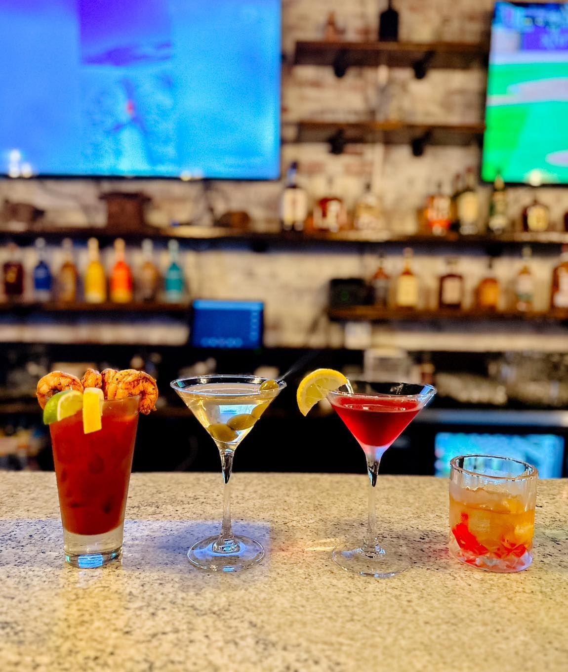 Three different types of drinks are sitting on a bar counter.