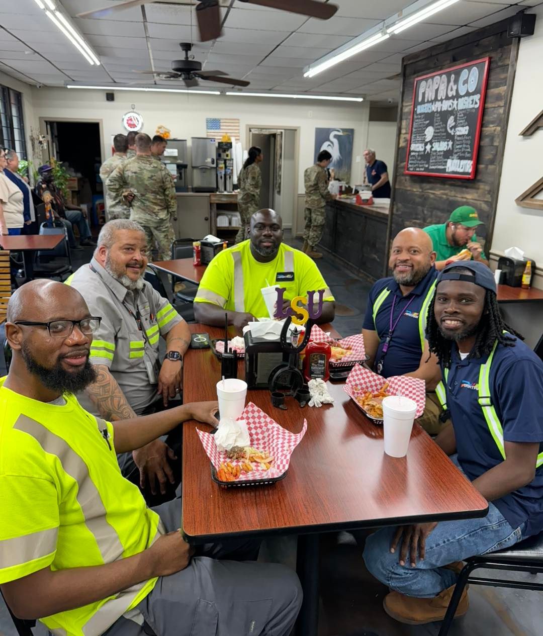 A group of men are sitting at tables in a restaurant.