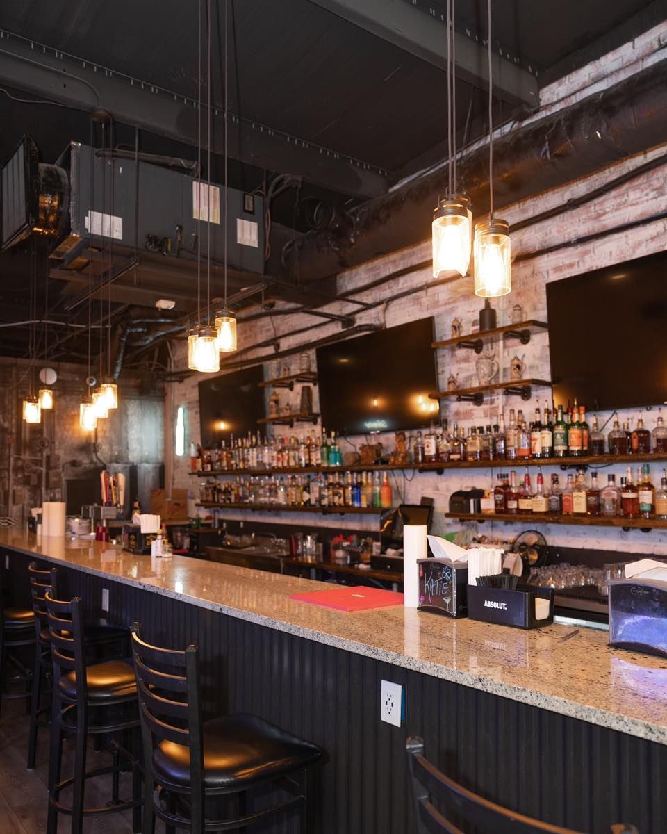 A long bar with a lot of bottles on it