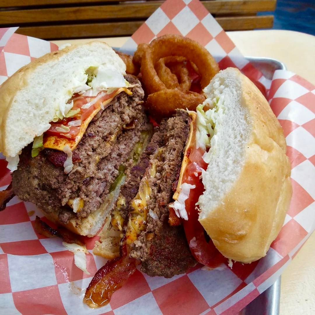A hamburger is cut in half on a checkered napkin