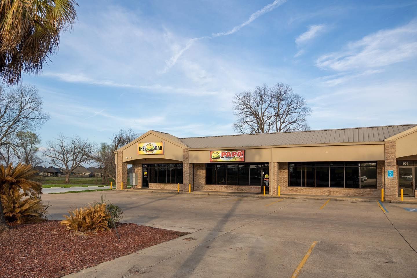 A building with a lot of windows and a parking lot in front of it.