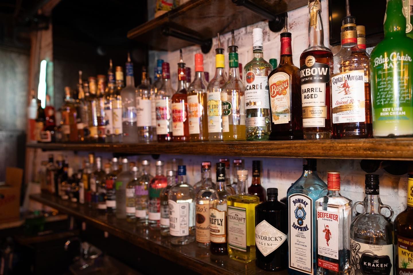 A bar filled with lots of bottles of liquor on shelves.