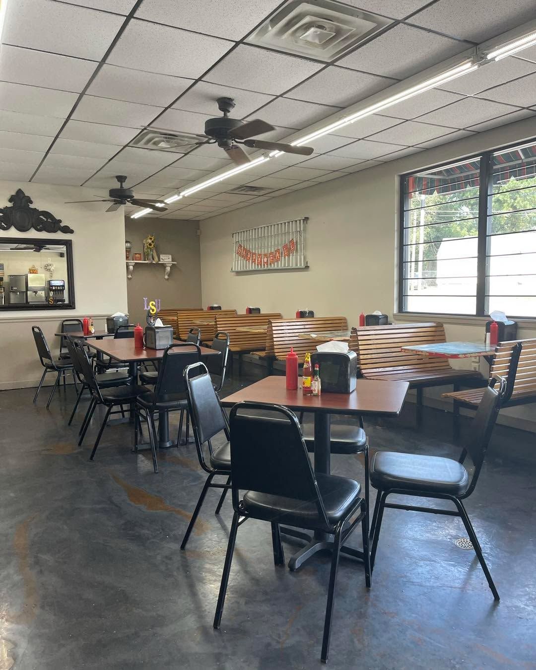 A restaurant with tables and chairs and a ceiling fan.