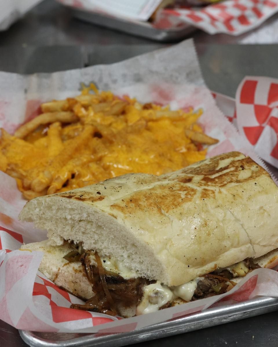 A sub sandwich and french fries on a tray