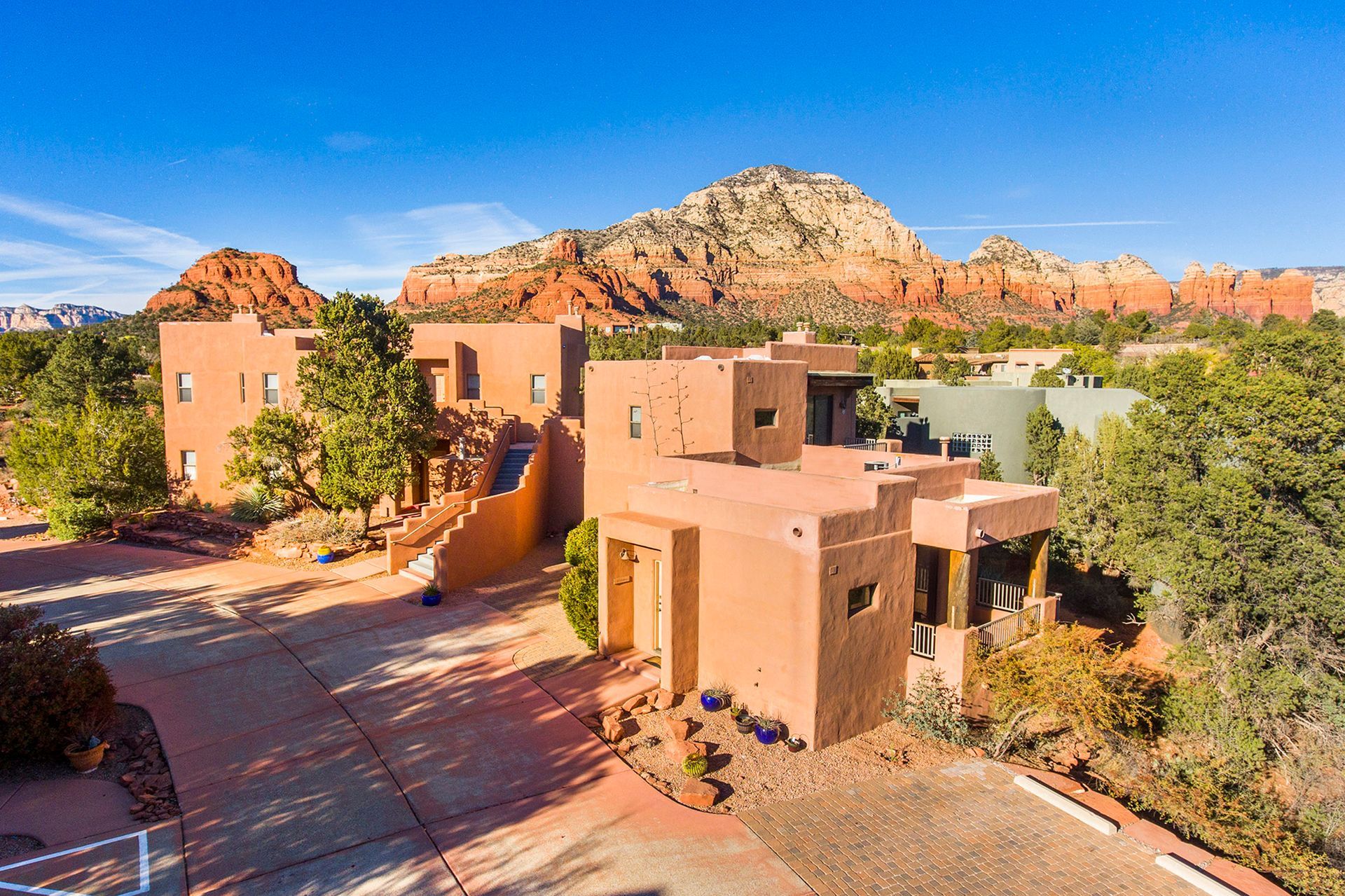 An aerial view of a house in the desert with mountains in the background.