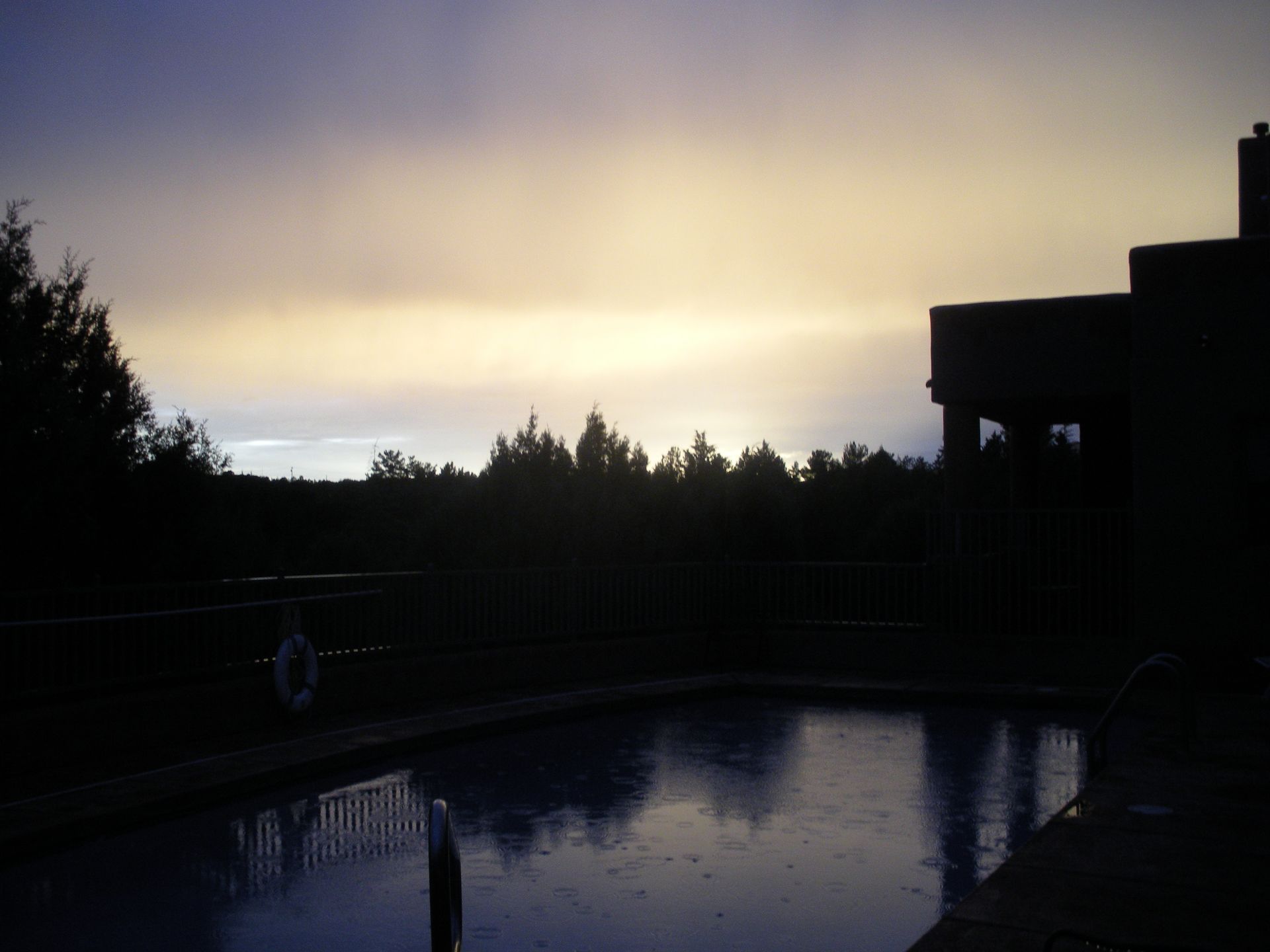 A swimming pool with a sunset in the background