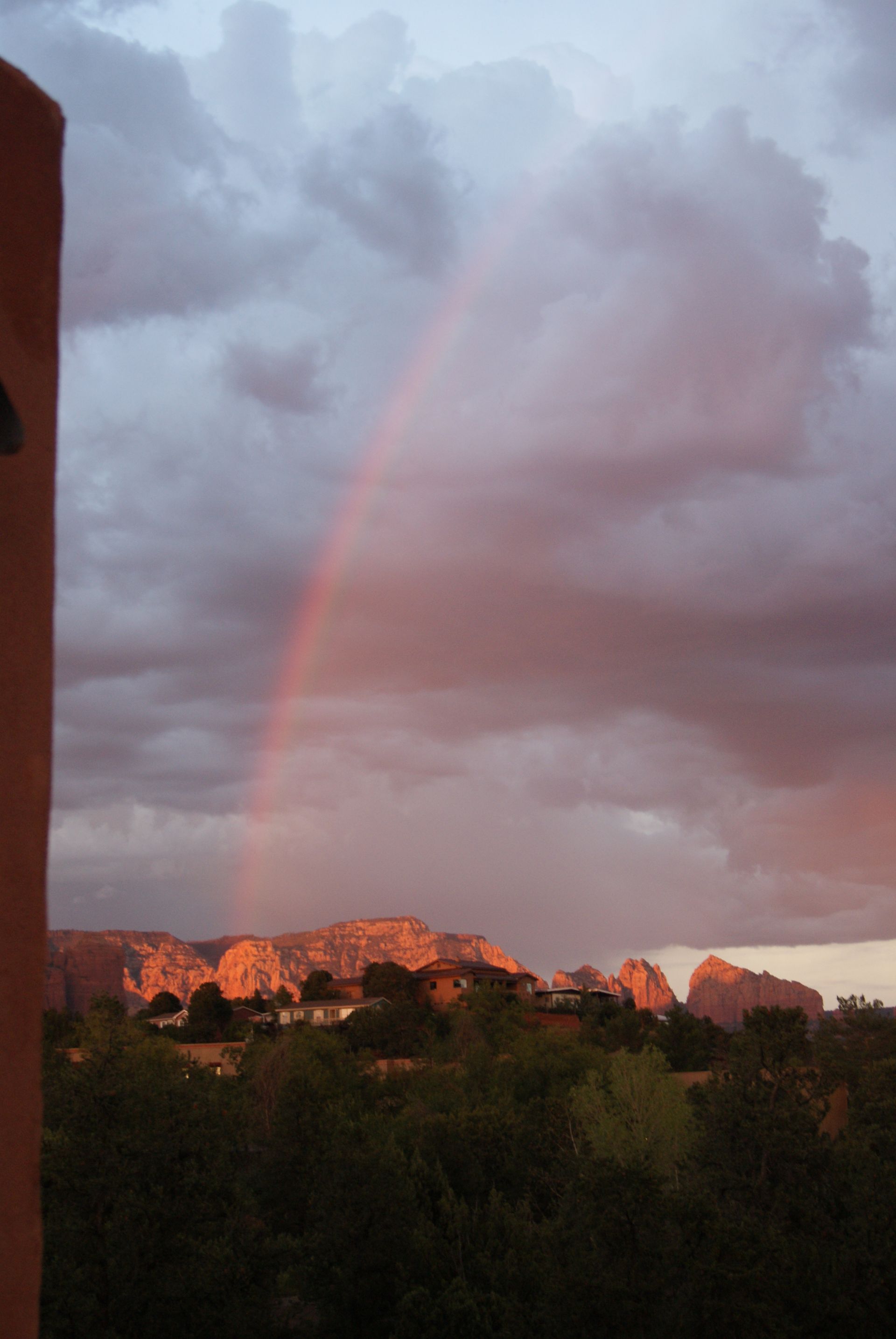 A rainbow is visible in the sky over a mountain range