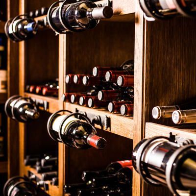 A row of wine bottles sitting on wooden shelves in a wine cellar.