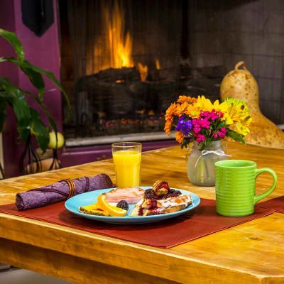 A wooden table topped with a plate of food and a green mug.