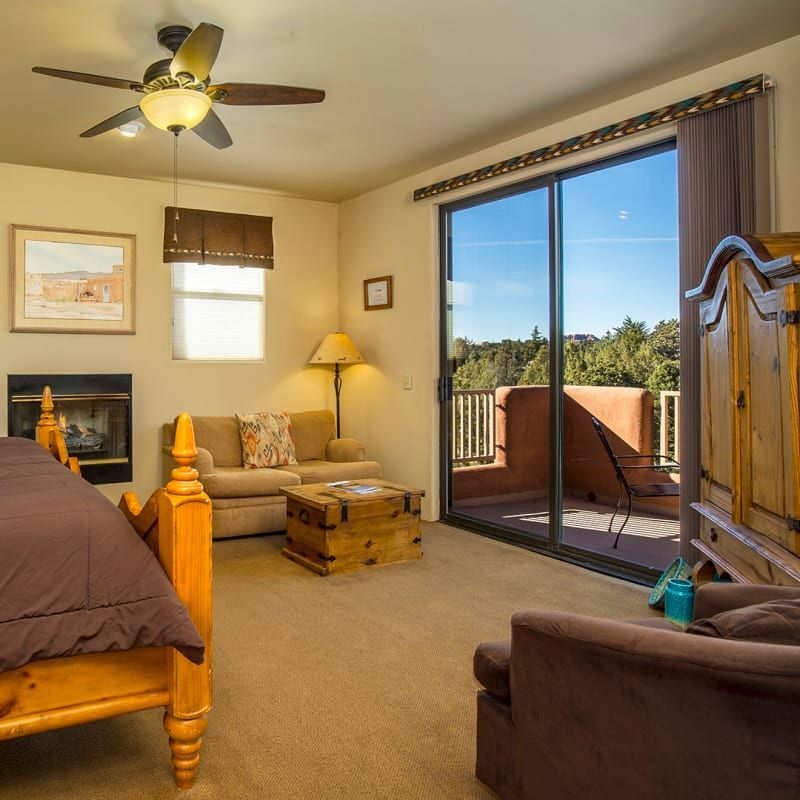 A bedroom with a ceiling fan and a sliding glass door