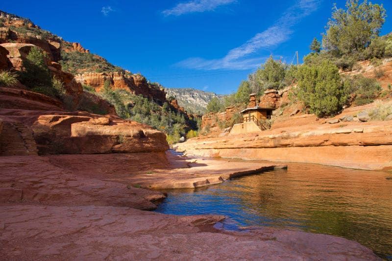 A river in the middle of a canyon with mountains in the background.