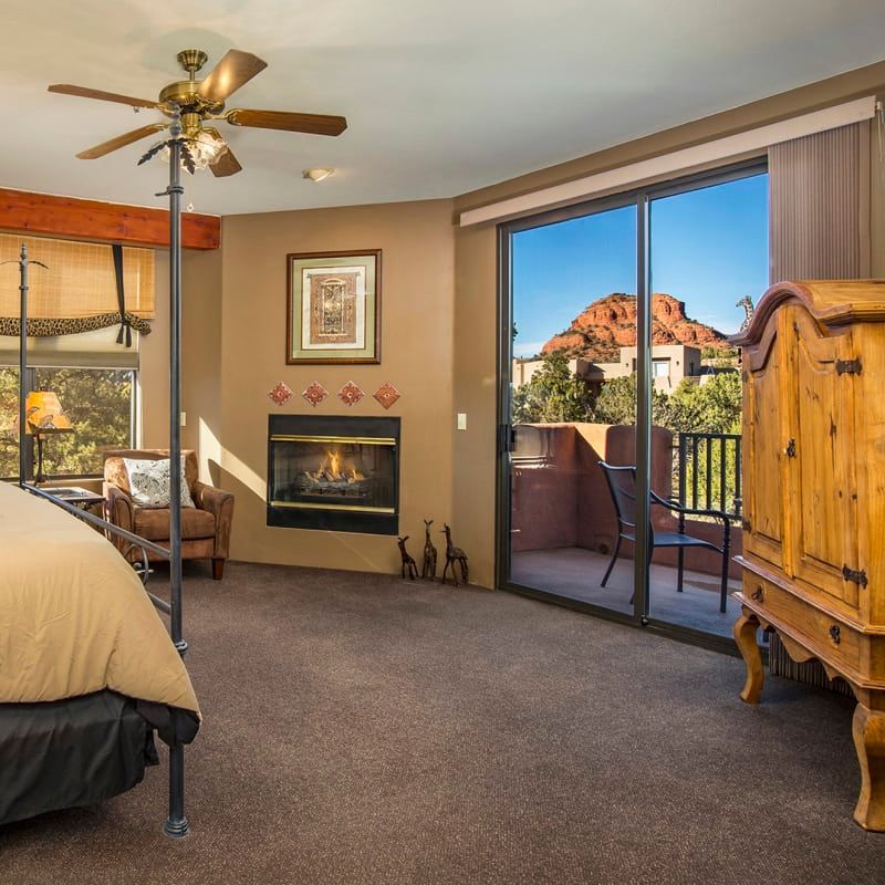 A bedroom with a fireplace and sliding glass doors