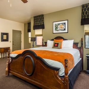 A bedroom with a king size bed and a ceiling fan.