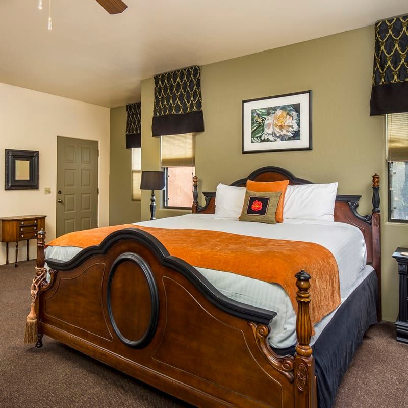 A bedroom with a large bed and a ceiling fan