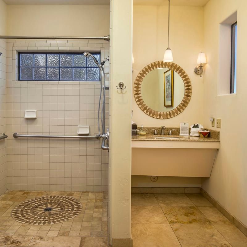 A bathroom with a walk in shower and a sink