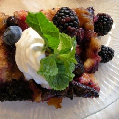A close up of a dessert with berries and whipped cream
