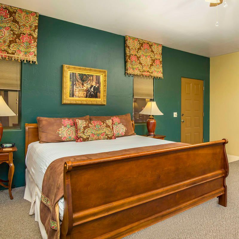 A bedroom with a king size bed and two lamps