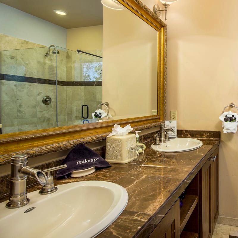 A bathroom with two sinks and a large mirror