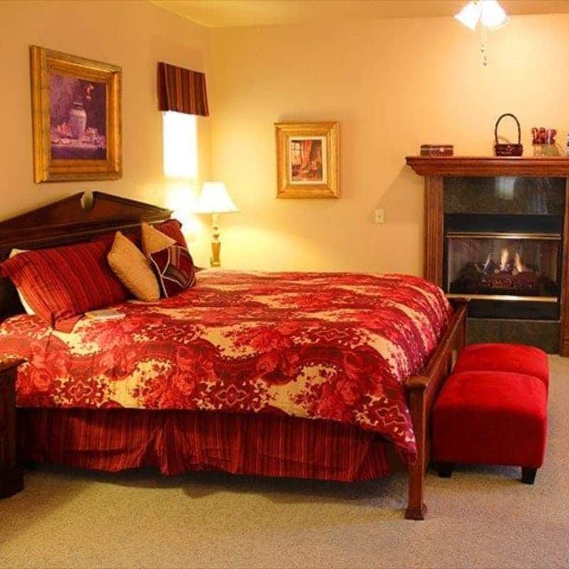 A bedroom with a large bed and a fireplace