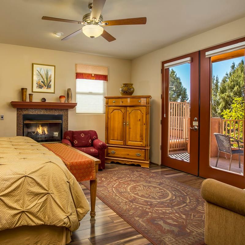 A bedroom with a fireplace and a ceiling fan