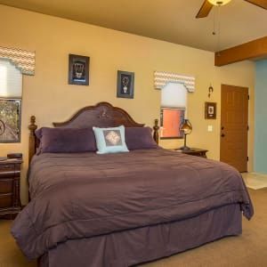 A bedroom with a king size bed and a ceiling fan.