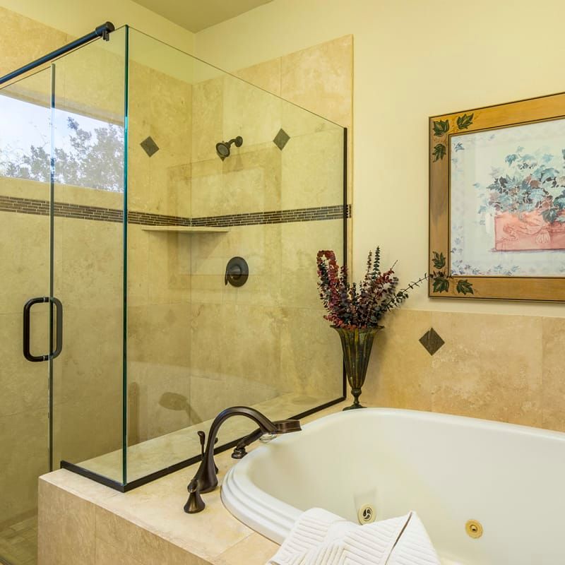A bathroom with a jacuzzi tub and a glass shower