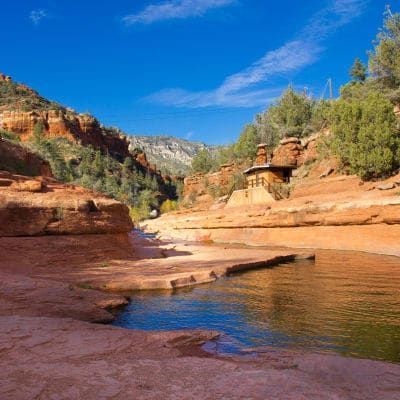 A river runs through a canyon surrounded by rocks and trees.
