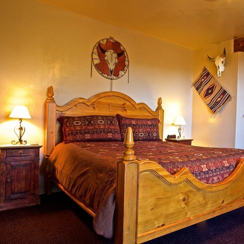 A bedroom with a bed and a skull on the wall