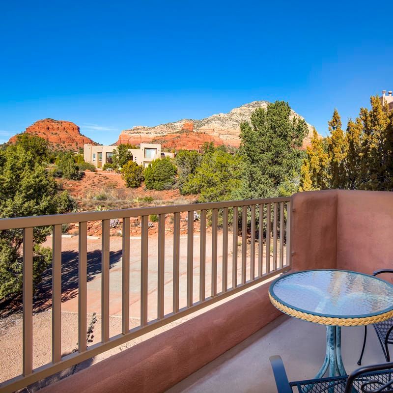 A balcony with a table and chairs with a view of mountains