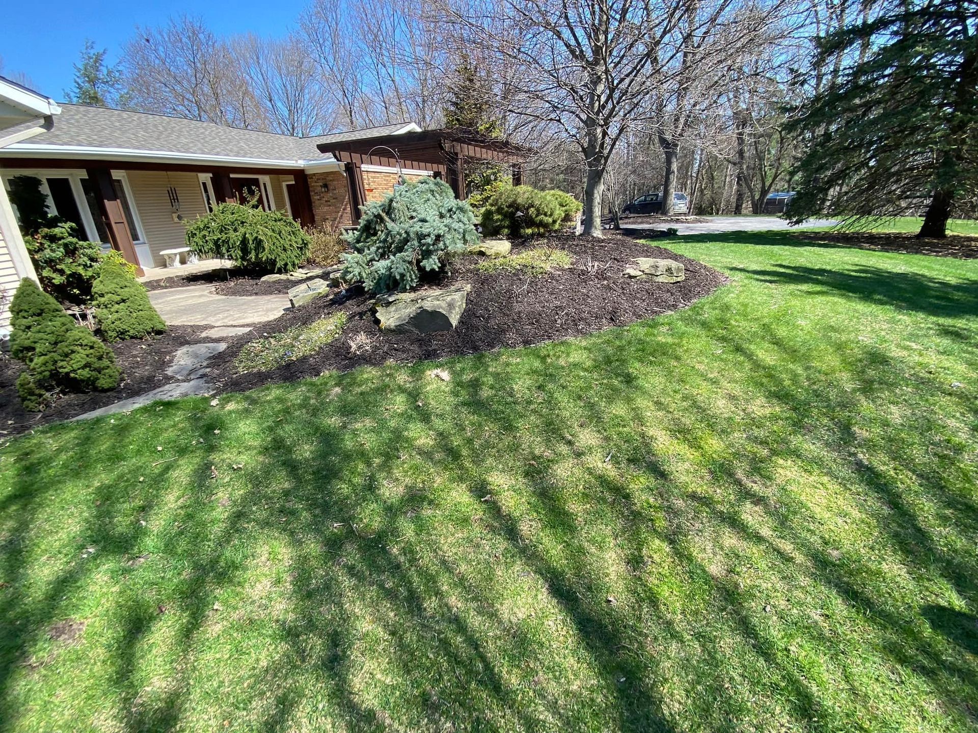 A lush green lawn in front of a house on a sunny day.