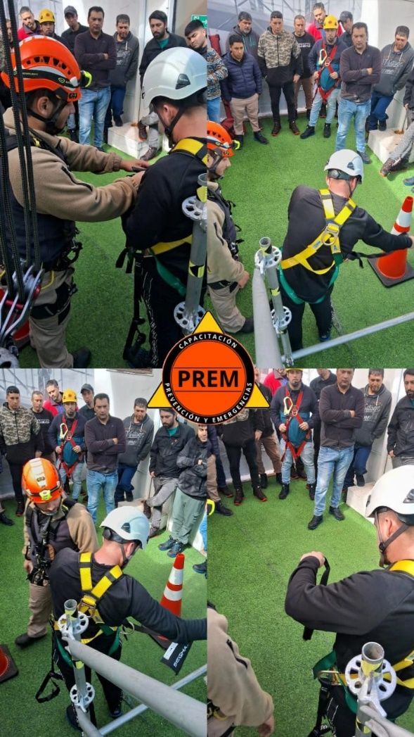 Los rescatistas con arneses practican rapel. Otros observan la instalación del césped artificial.