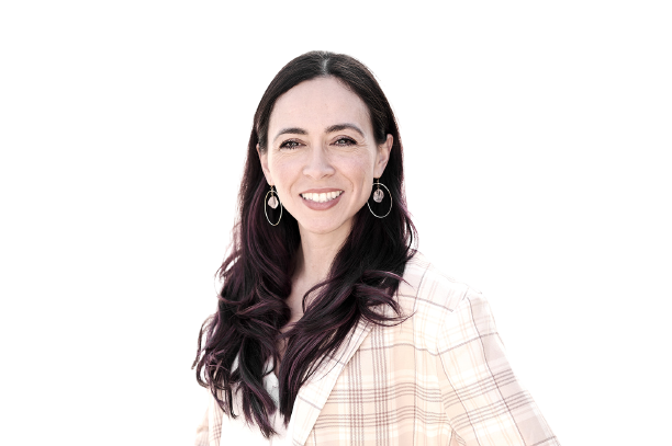 A woman wearing a plaid jacket and earrings is smiling for the camera.