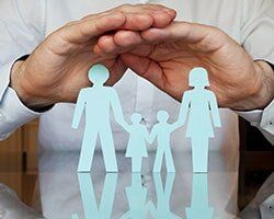 Paper Cut-out of a Family with Two Hands of a Man Above — Family Medical Clinic in Asheville,NC