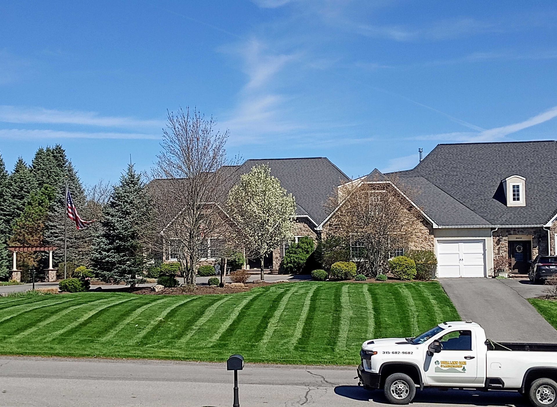 A white truck is parked in front of a house.