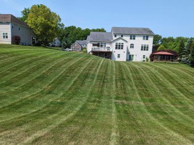 An aerial view of a lush green lawn in front of a house.