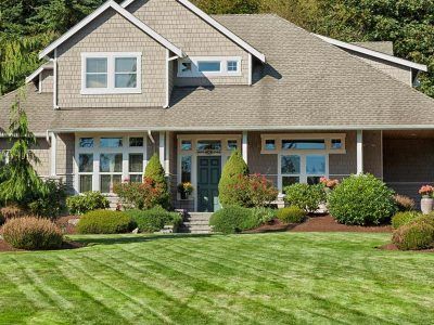 A large house with a lush green lawn in front of it.