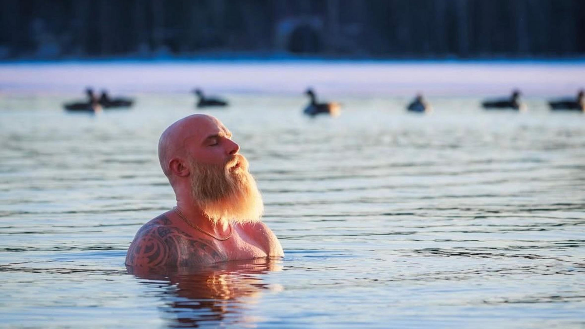 Mies uimassa avannossa. Ankkoja näkyy taustalla.