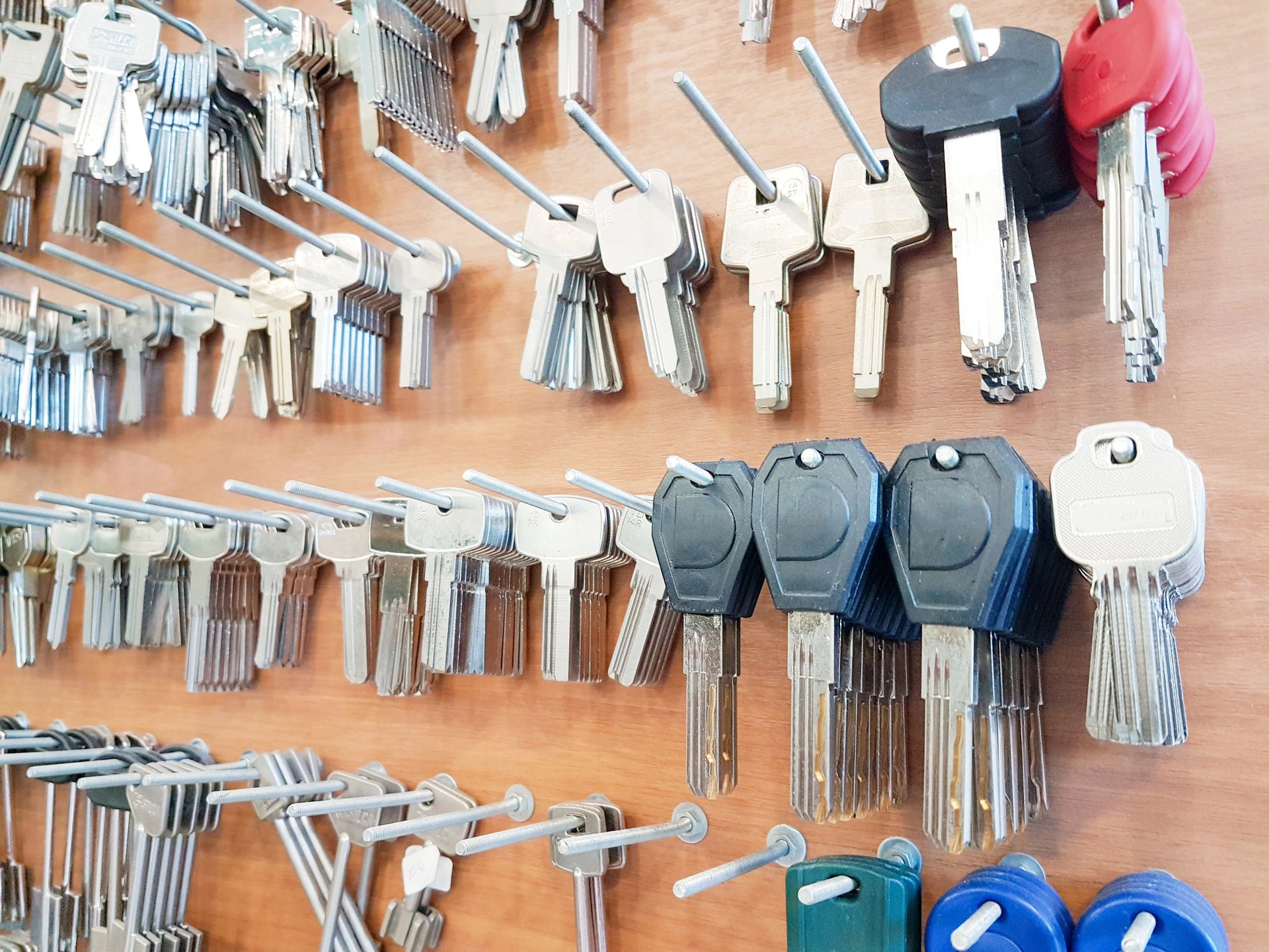 Un manojo de llaves está colgado en una pared de madera.