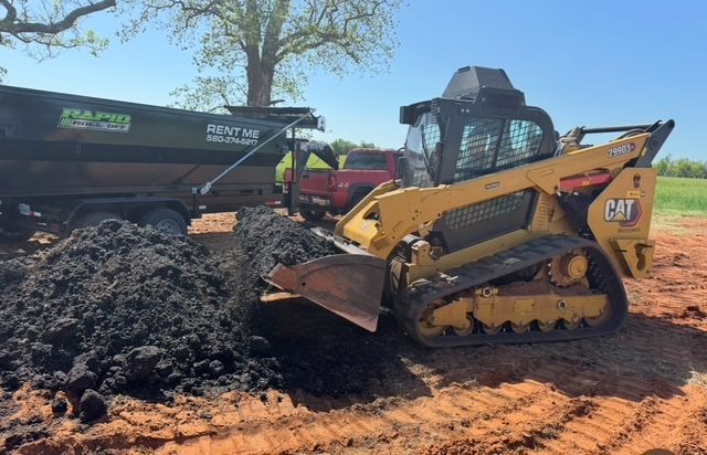 A pile of bricks is sitting next to a bulldozer on a construction site.