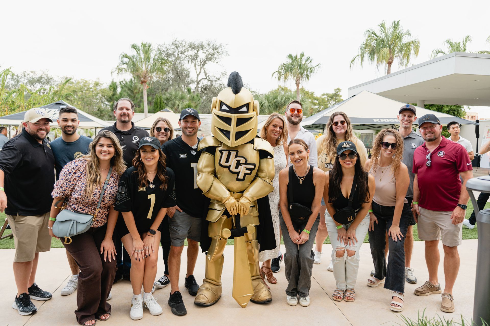 Group of people posing with UCF mascot in an outdoor setting.