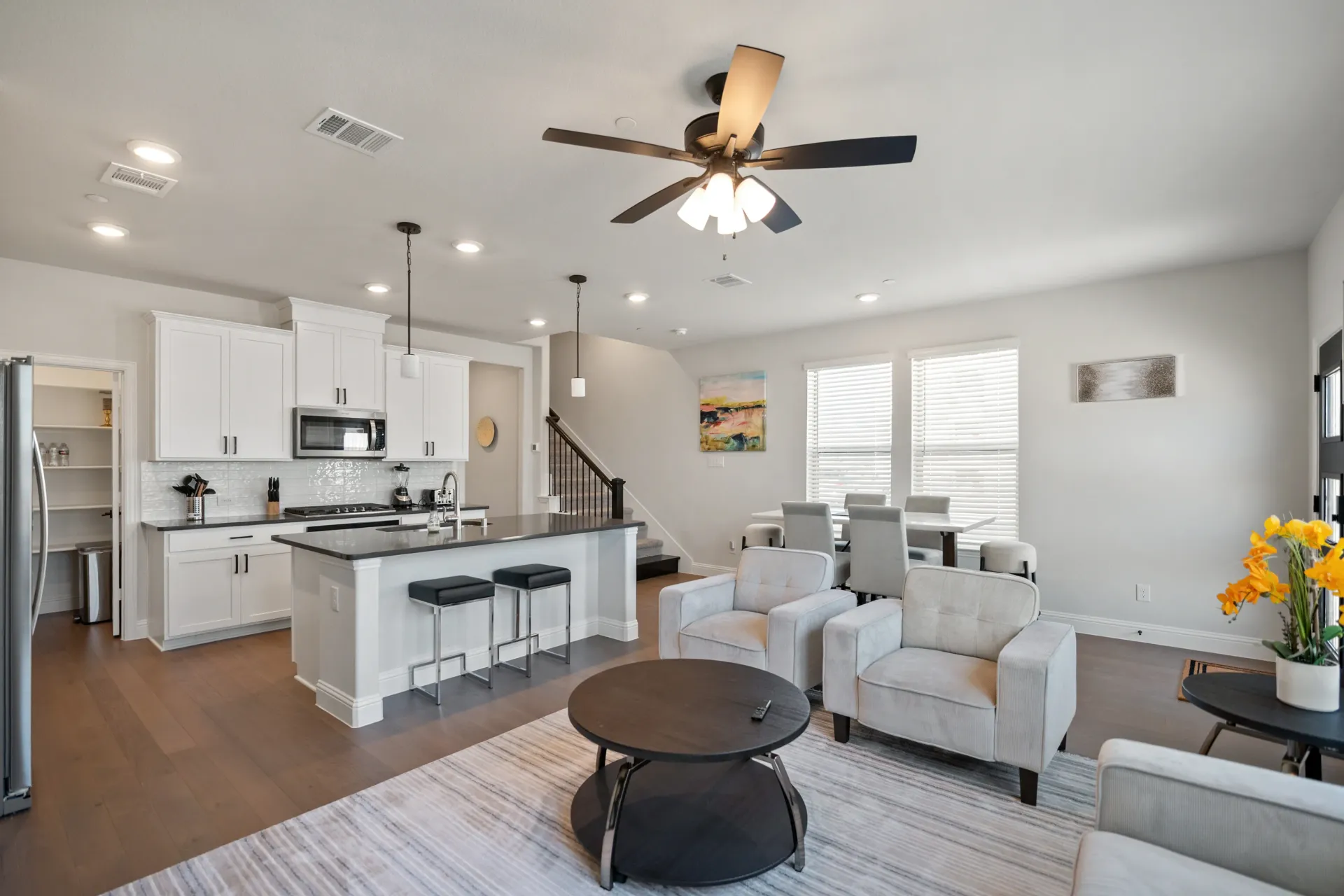 Dining room with table and chairs, stairs, and a chandelier.