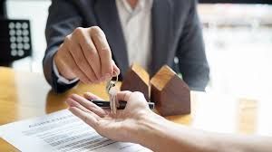 A man is giving a woman a set of keys.